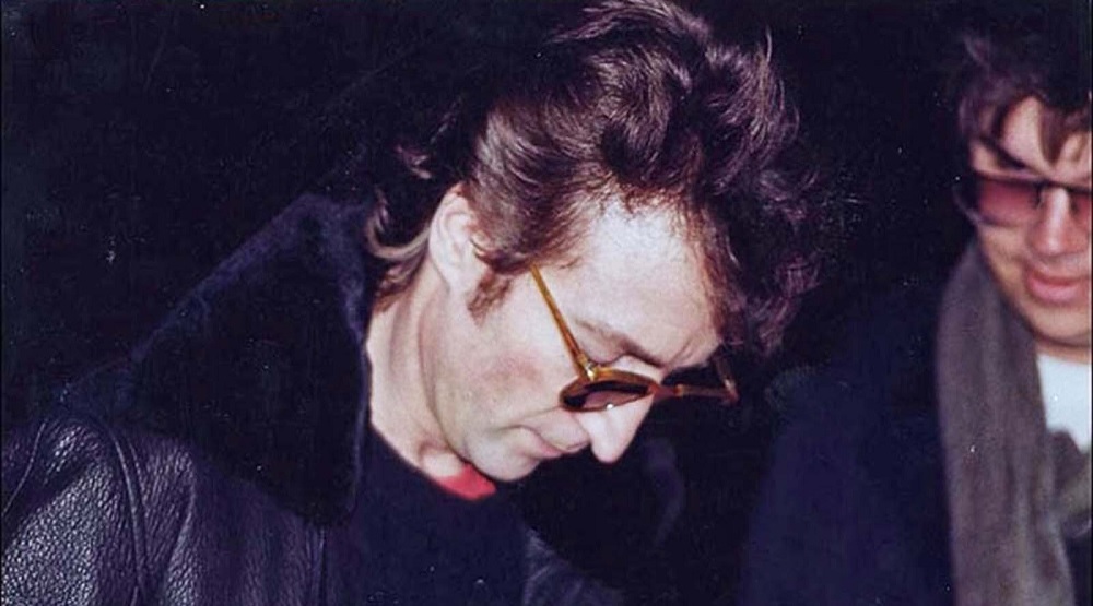 Джон Леннон подписывает копию «Double Fantasy» Марку Чепмену (виден справа). До смерти Леннона от выстрелов Чепмена остается несколько часов/ Фото: Paul Goresh